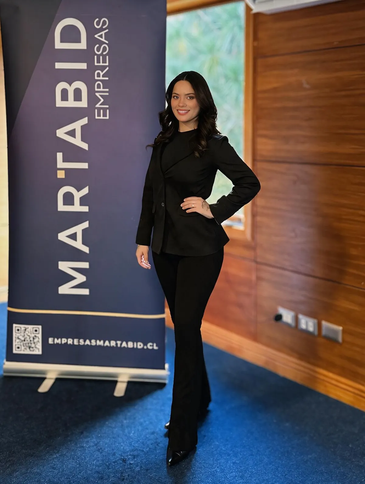 Anfitriona junto a señalética de Martabid Empresas en evento de Temuco.